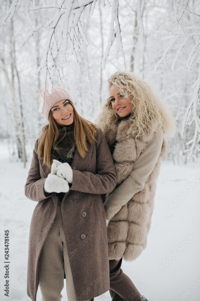 Photo of two blonde women on walk in winter forest Photo of two blonde women on walk in winter forest
