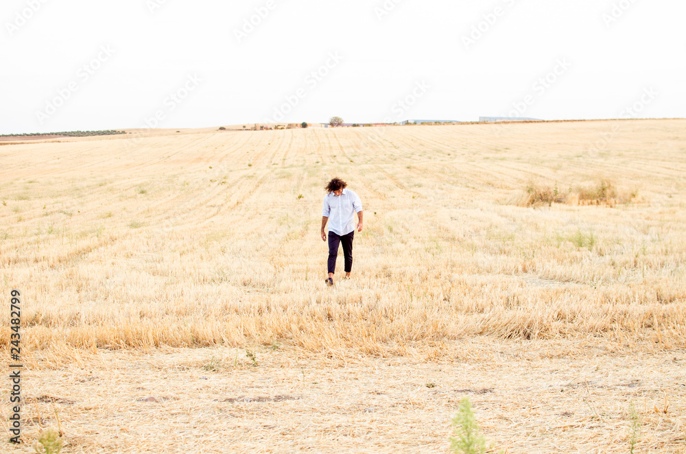 elegant young man with shirt walking and running through the field elegant young man with shirt walking and running through the field