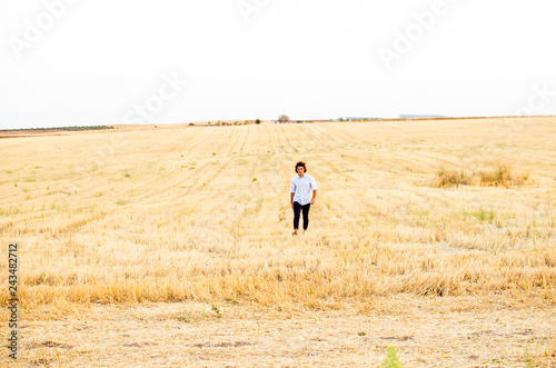 elegant young man with shirt walking and running through the field