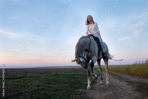 Girl and horse at sunset, jumping over the field © alex_marina