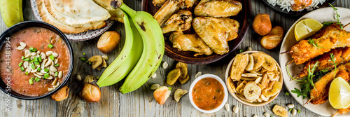 West african food concept. Traditional Wset African dishes assortment - peanut soup, jollof rice, grilled chicken wings, dry fried bananas plantains, nigerian chicken kebabs, meat pies, banner photo