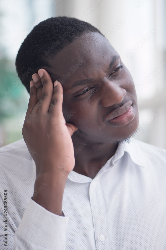 portrait of stressed sick black man with headache; ill african man suffers from headache, vertigo, dizziness, migraine, stress, depression, hangover concept; adult african man model portrait of stressed sick black man with headache; ill african man suffers from headache, vertigo, dizziness, migraine, stress, depression, hangover concept; adult african man model