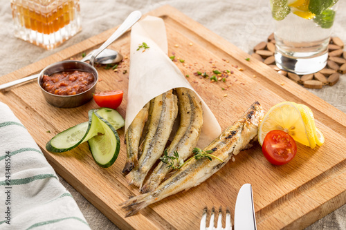 Seafood grilled sardines served with vegetables in traditional Greek tavern