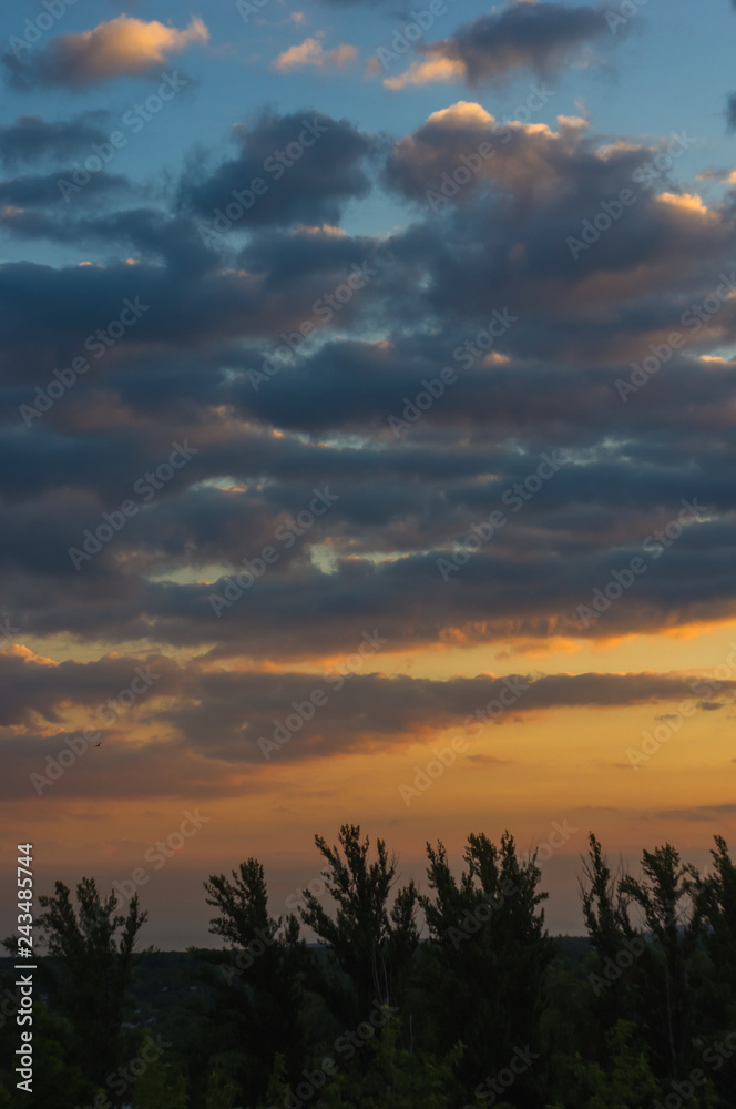 Landscape with dramatic light - beautiful golden sunset with saturated sky and clouds.