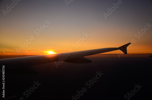 Tableau sur toile Airplane flying above clouds at sunrise. Aerial window view