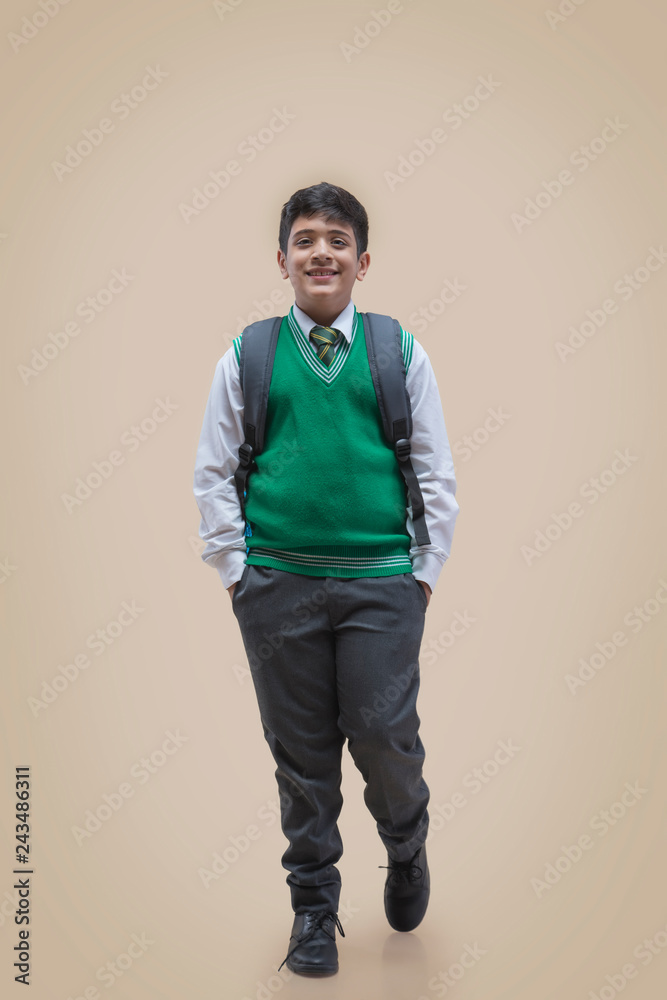Portrait of schoolboy with hands in pockets over color background Portrait of schoolboy with hands in pockets over color background