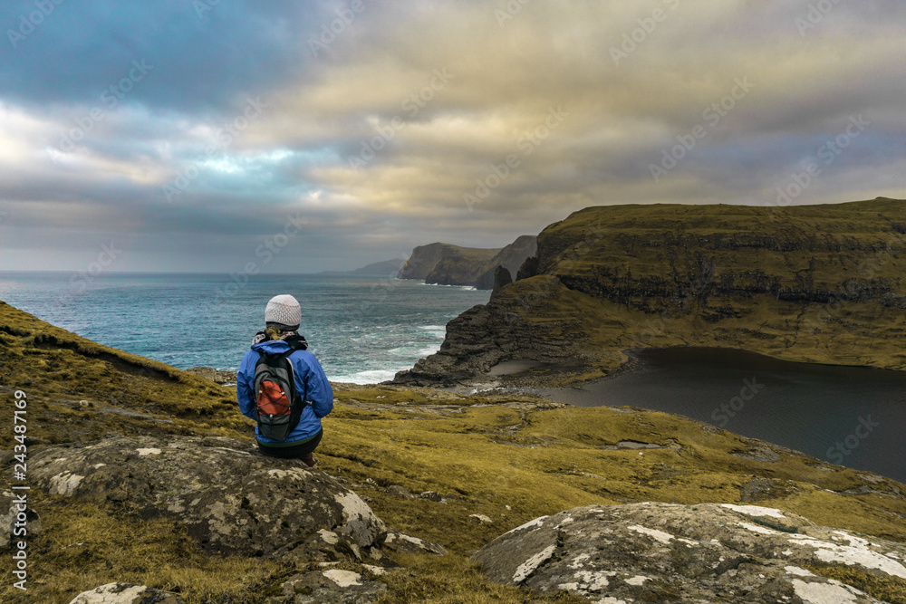 Young woman looking out to sea over cliffs. Girl Travelling in beautiful landscape. Tourist travel landscape mockup 