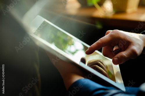 A man works in a tablet with a natural light source