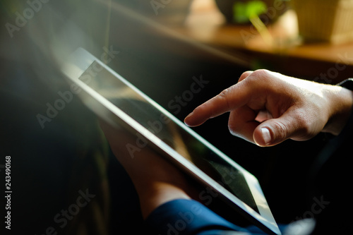 A man works in a tablet with a natural light source