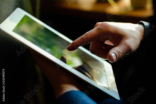 A man works in a tablet with a natural light source