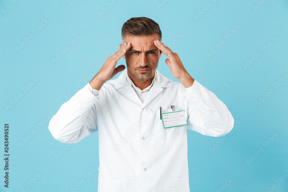 Tired man doctor wearing unifrom standing isolated Tired man doctor wearing unifrom standing isolated