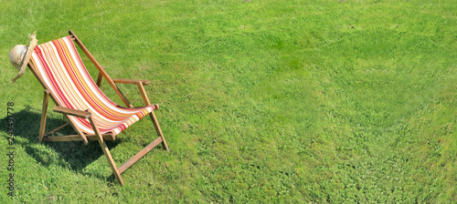 deckchair on greenery grass in a garden in panoramic size  photo