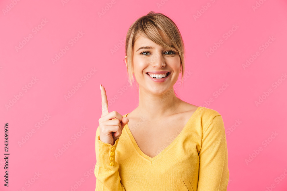 Cheerful young blonde woman pointing finger away Cheerful young blonde woman pointing finger away