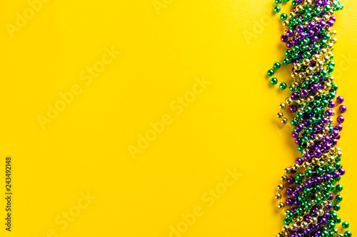 Photographie Mardi gras carnival concept - beads on yellow background, top view