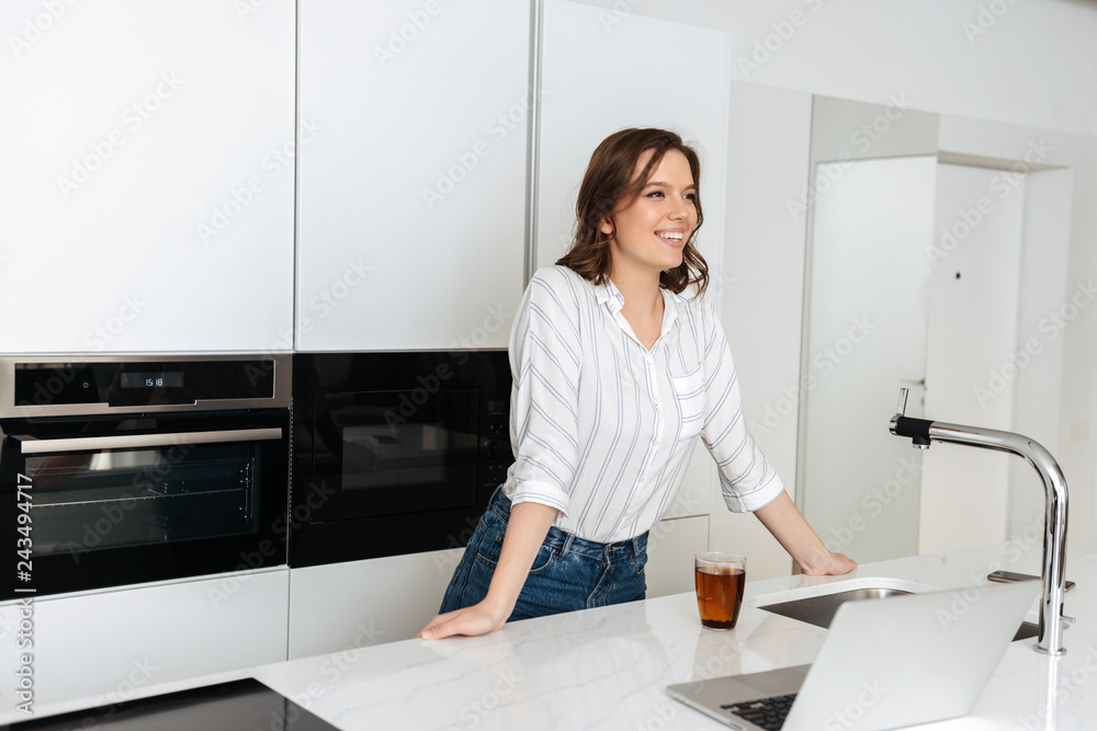 Happy young businesswoman standing at the kitchen Happy young businesswoman standing at the kitchen