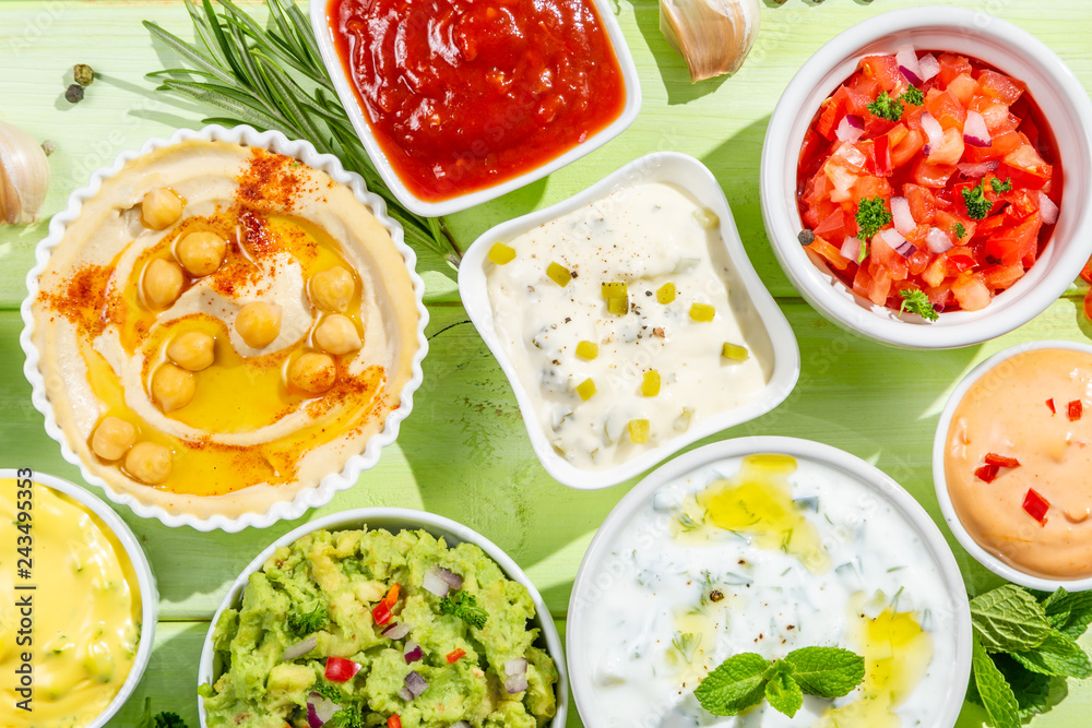 Selection of sauces in white bowls on white bowls, top view Selection of sauces in white bowls on white bowls, top view