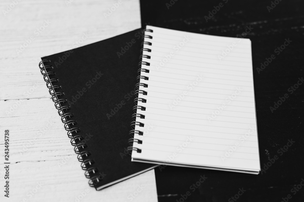 black and white notepads on opposite coor surface facing each other,