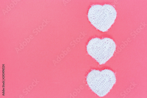 White flyffy knitted heart on pink paper background with copy space. Card for wishes with Valentine’s day, birthday, holidays. photo