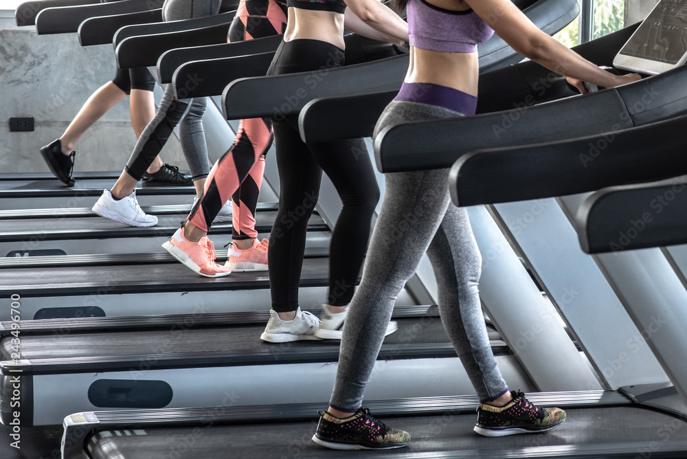 Group of women running on treadmill in gym.