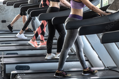 Group of women running on treadmill in gym.