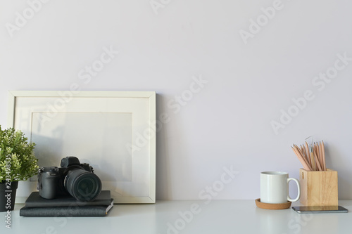Fototapeta Naklejka Na Ścianę i Meble -  Photographer desk concept. designers table, photo camera, notebook paper, coffee and photo frame Copy space, background. - Image.