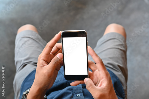 Closeup man hands holding smart phone with blank copy space screen for your text message or information content, male reading text message on cell telephone during in urban setting. © Prathankarnpap