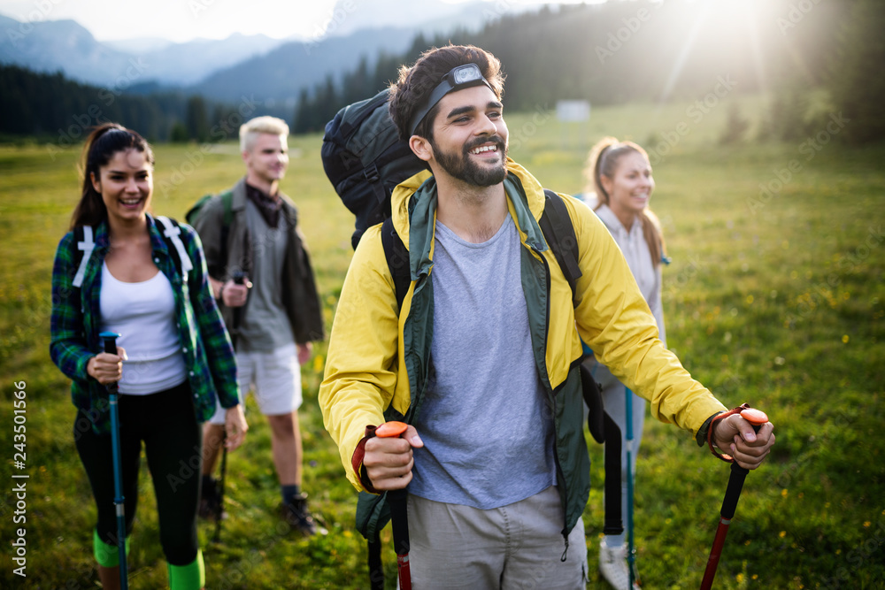 Adventure, travel, tourism, hike and people concept - group of smiling friends with backpacks and map outdoors