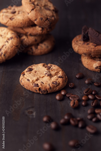 Chocolate chip cookies on old wooden table with coffee beans. Homemade snack.