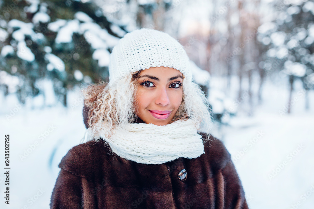 Close-up portrait of beautiful young afro american woman in winter forest