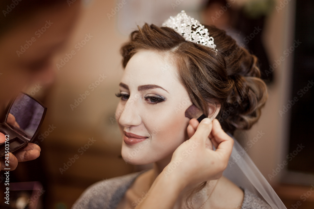 Make-up artist doing makeup to the bride on the wedding day. large portrait