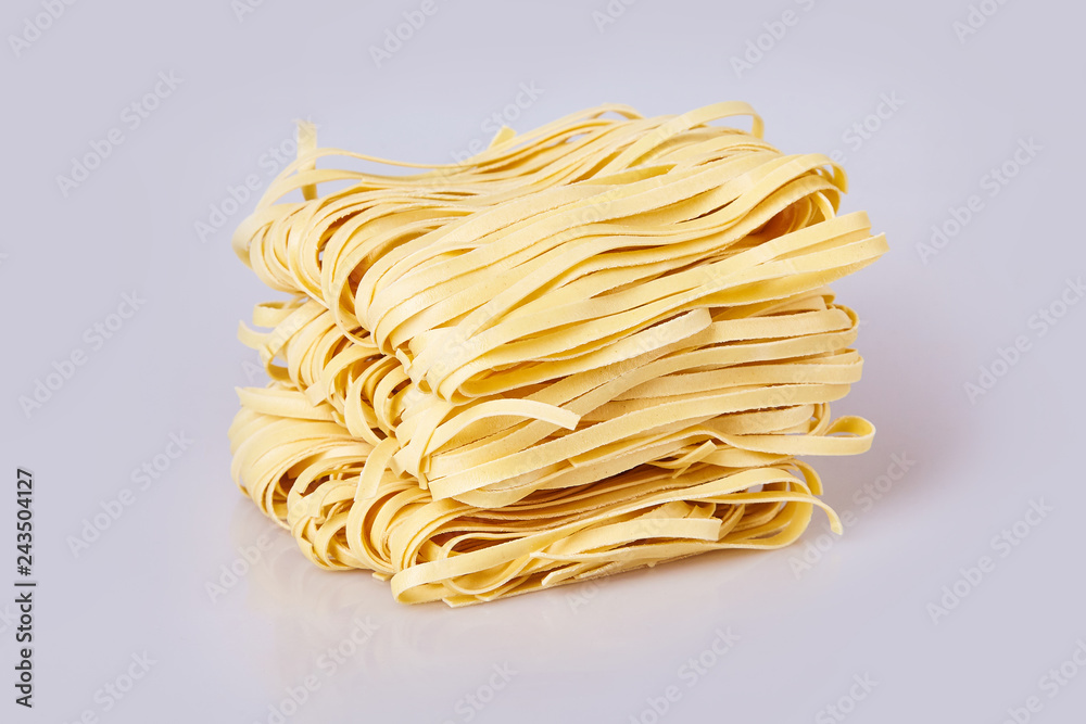 Dry thick rolled noodles square shape. Capelli d'angelo, Angel's hair - pasta.  Homemade italian pasta tagliatelle. Italian Cuisine. Egg noodles. Isolated on white background