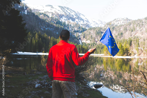 hiker with red sweater and flag from the european union outdoor somewhere in the austrian alps