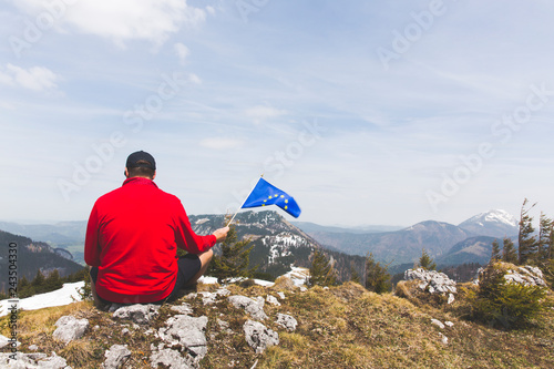 hiker with red sweater and flag from the european union outdoor somewhere in the austrian alps