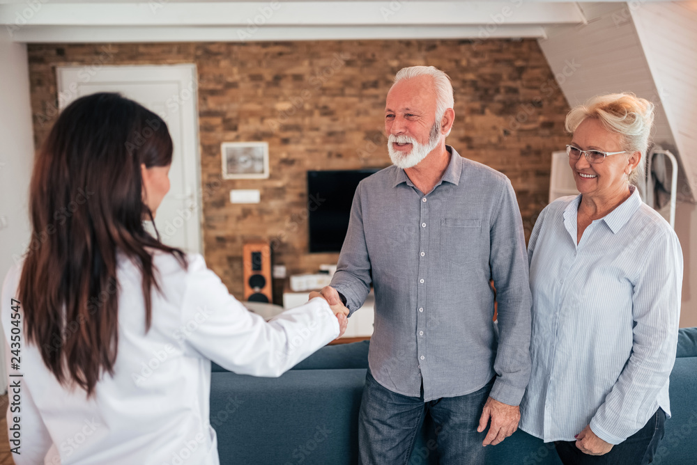 Fototapeta premium Smiling senior patient and doctor shaking hands.