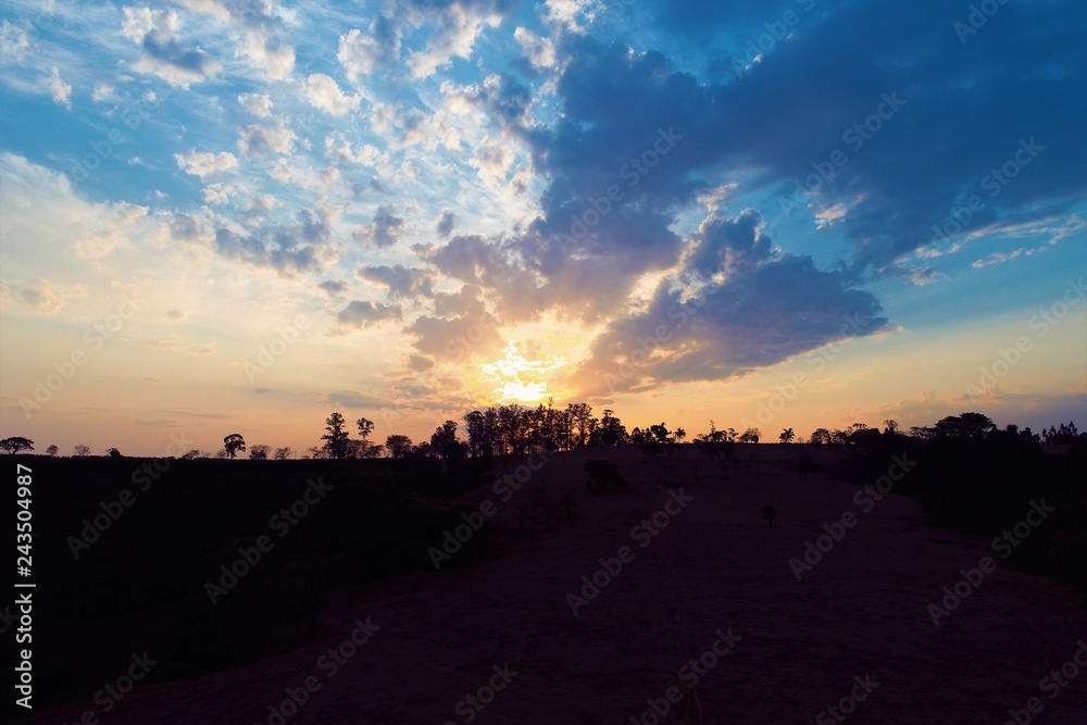 Aerial view of a sunset with sunbeams from forest. Countryside view. Fantastic landscape. Great colors and contrast