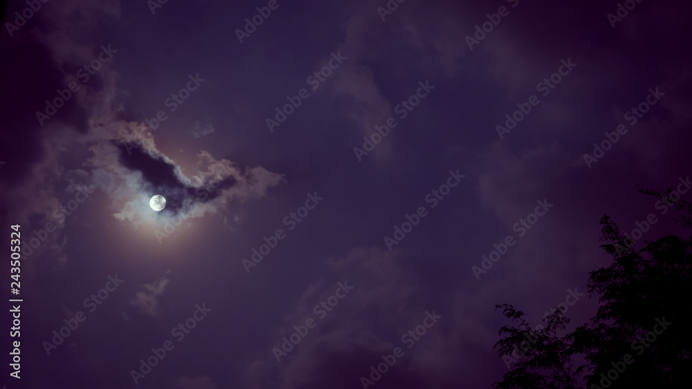 night sky and astronomy on violet or purple background concept from full moon behind the cloud during watch spectacular winter solstice event in december of 2018