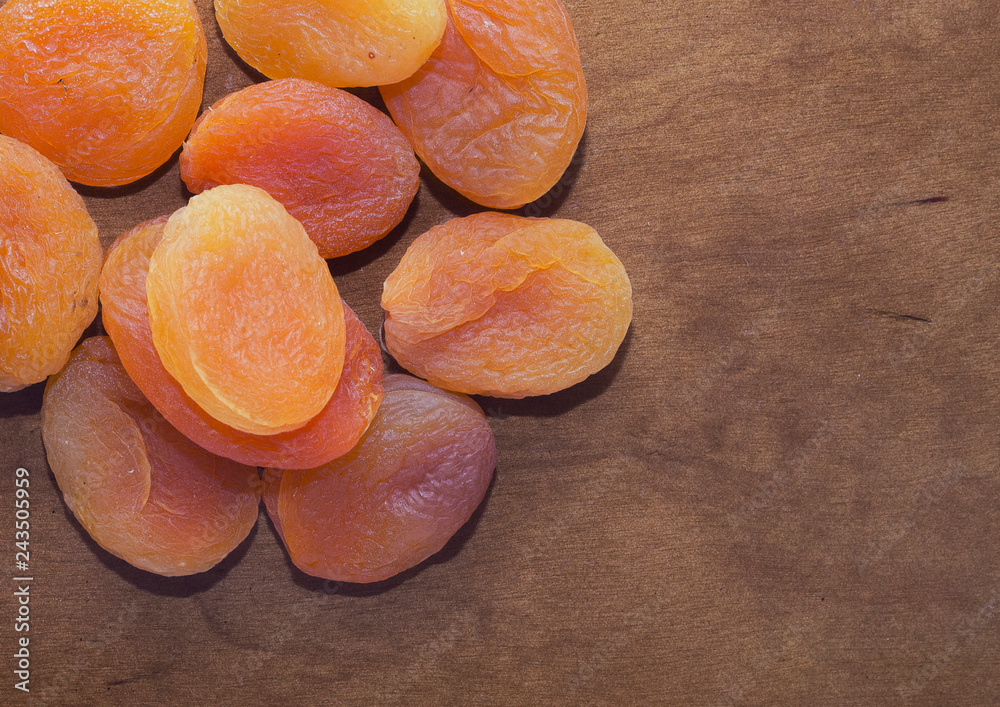 Colored dried apricots on wooden table, closeup Colored dried apricots on wooden table, closeup