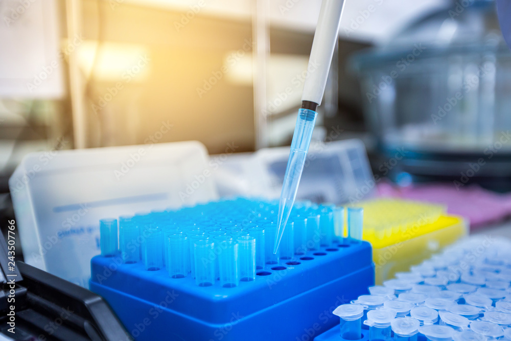 Scientists are using a micropipette to suck the solution for scientific experiments. Instruments