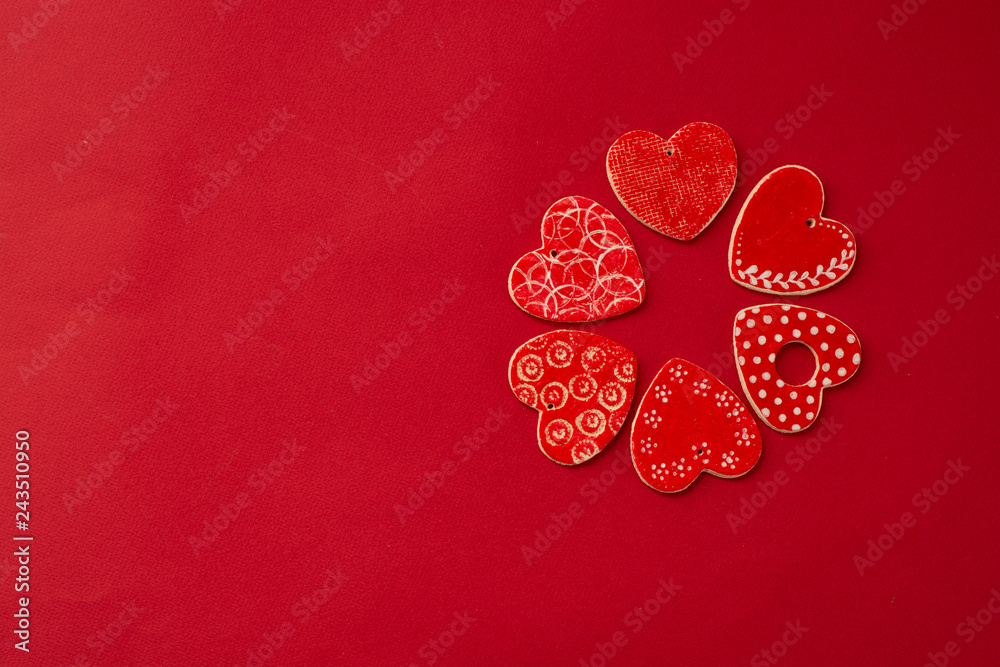 Fototapeta premium Red decorative hearts over red background. Valentine's Day, love celebration. Copy space. Top view.