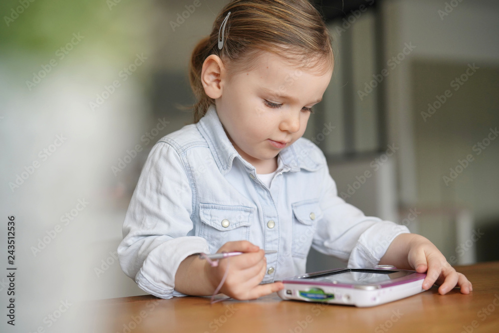 Young child playing by herself on tablet at home Young child playing by herself on tablet at home