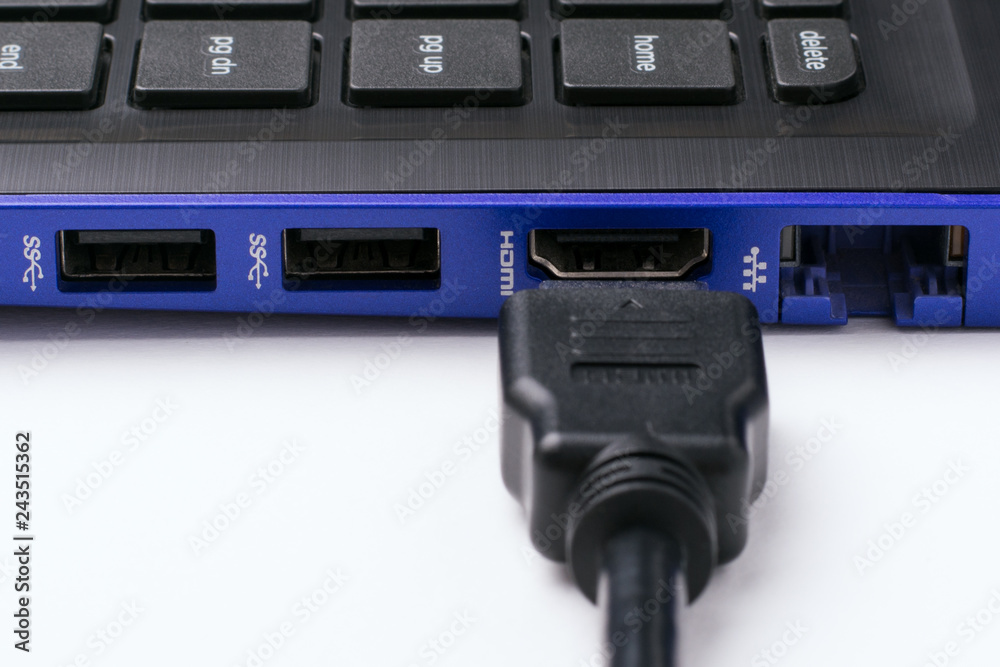 HDMI cable near the HDMI port of the modern blue laptop on a white background. Horizontal shot
