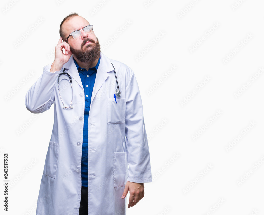 Young caucasian doctor man wearing medical white coat over isolated background with hand on chin thinking about question, pensive expression. Smiling with thoughtful face. Doubt concept.