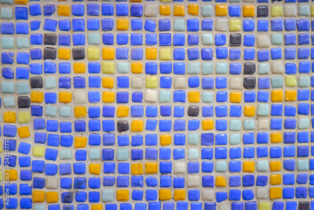 Ceramic square wall sample shot as background. All small squares various shades of blue and yellow Ceramic square wall sample shot as background. All small squares various shades of blue and yellow
