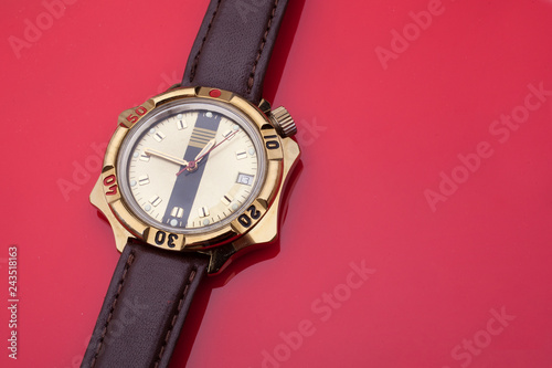 close up view of brown leather man's wrist watch on red background