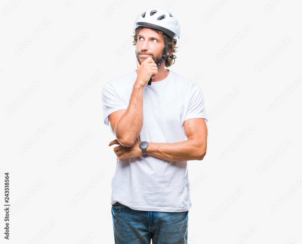 Handsome hispanic cyclist man wearing safety helmet over isolated background with hand on chin thinking about question, pensive expression. Smiling with thoughtful face. Doubt concept. Handsome hispanic cyclist man wearing safety helmet over isolated background with hand on chin thinking about question, pensive expression. Smiling with thoughtful face. Doubt concept.