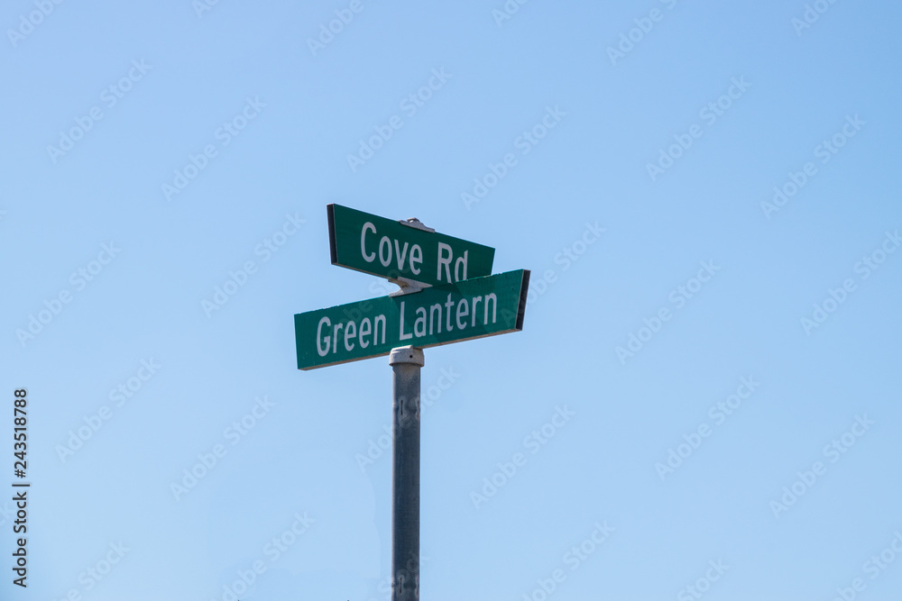 Street sign Cove Rd and Green Lantern on metal post with blue background Street sign Cove Rd and Green Lantern on metal post with blue background