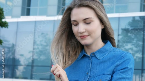 Charming lady trying to comb brush her hair in a heavy wind