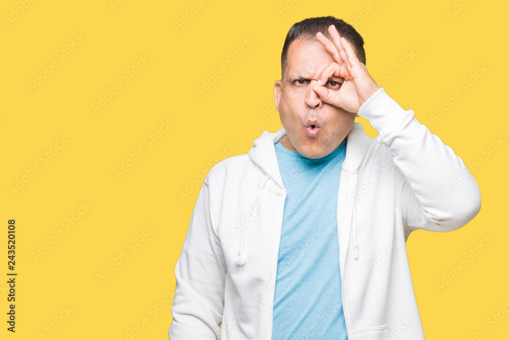 Middle age arab man wearing sweatshirt over isolated background doing ok gesture shocked with surprised face, eye looking through fingers. Unbelieving expression. Middle age arab man wearing sweatshirt over isolated background doing ok gesture shocked with surprised face, eye looking through fingers. Unbelieving expression.