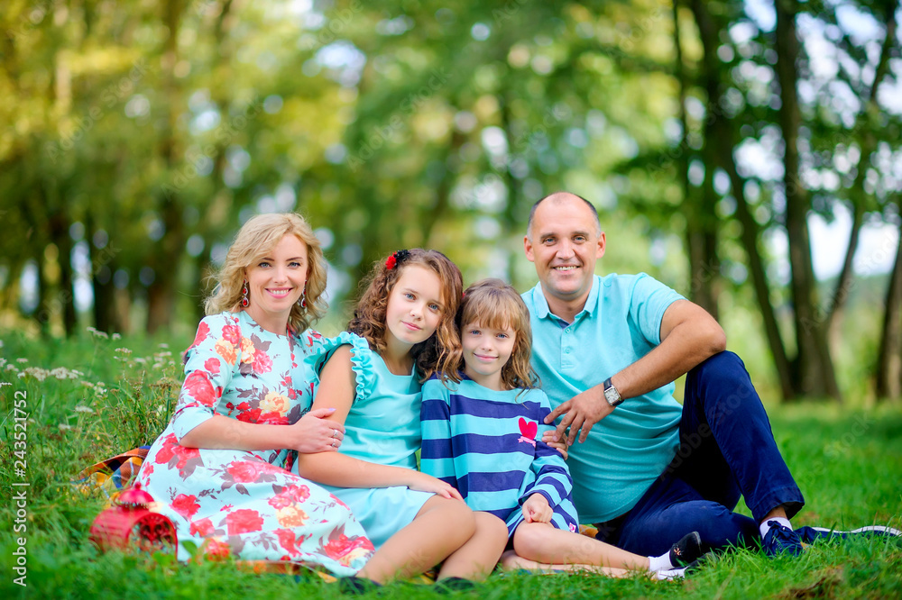 happy family in a beautiful autumn park sitting on the grass hugging and smiling happy family in a beautiful autumn park sitting on the grass hugging and smiling
