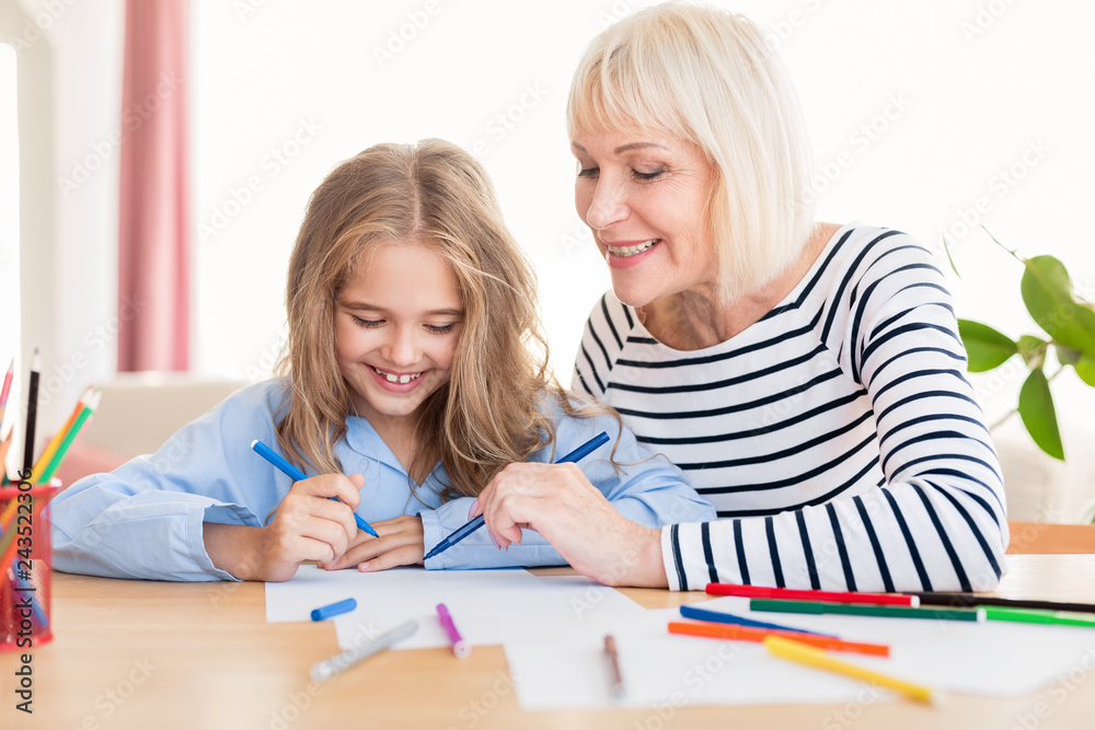 Child with her granny drawing and laughing Child with her granny drawing and laughing